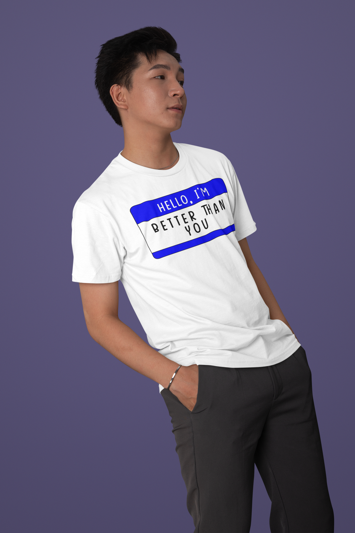 Hello I'm Better Than You name tag T-shirt in white, man wearing it against purple backdrop, sarcastic tee