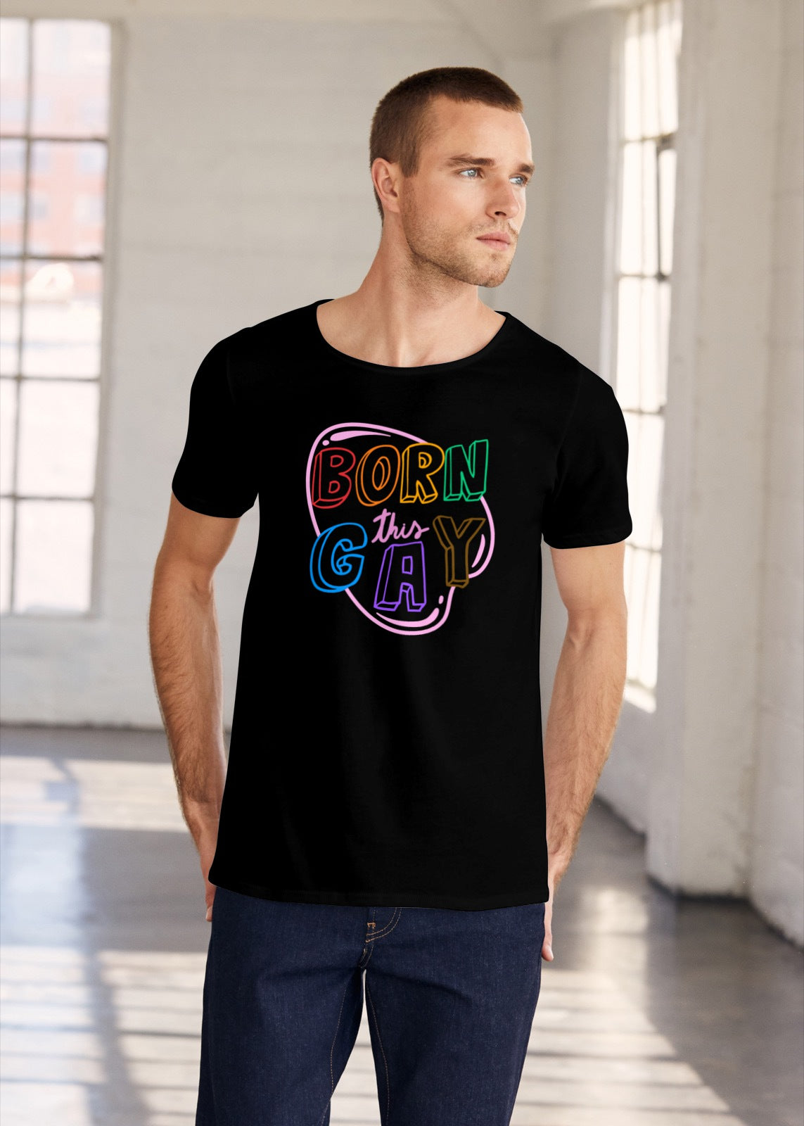 A man wearing a rainbow-themed black t-shirt that says Born This Gay.