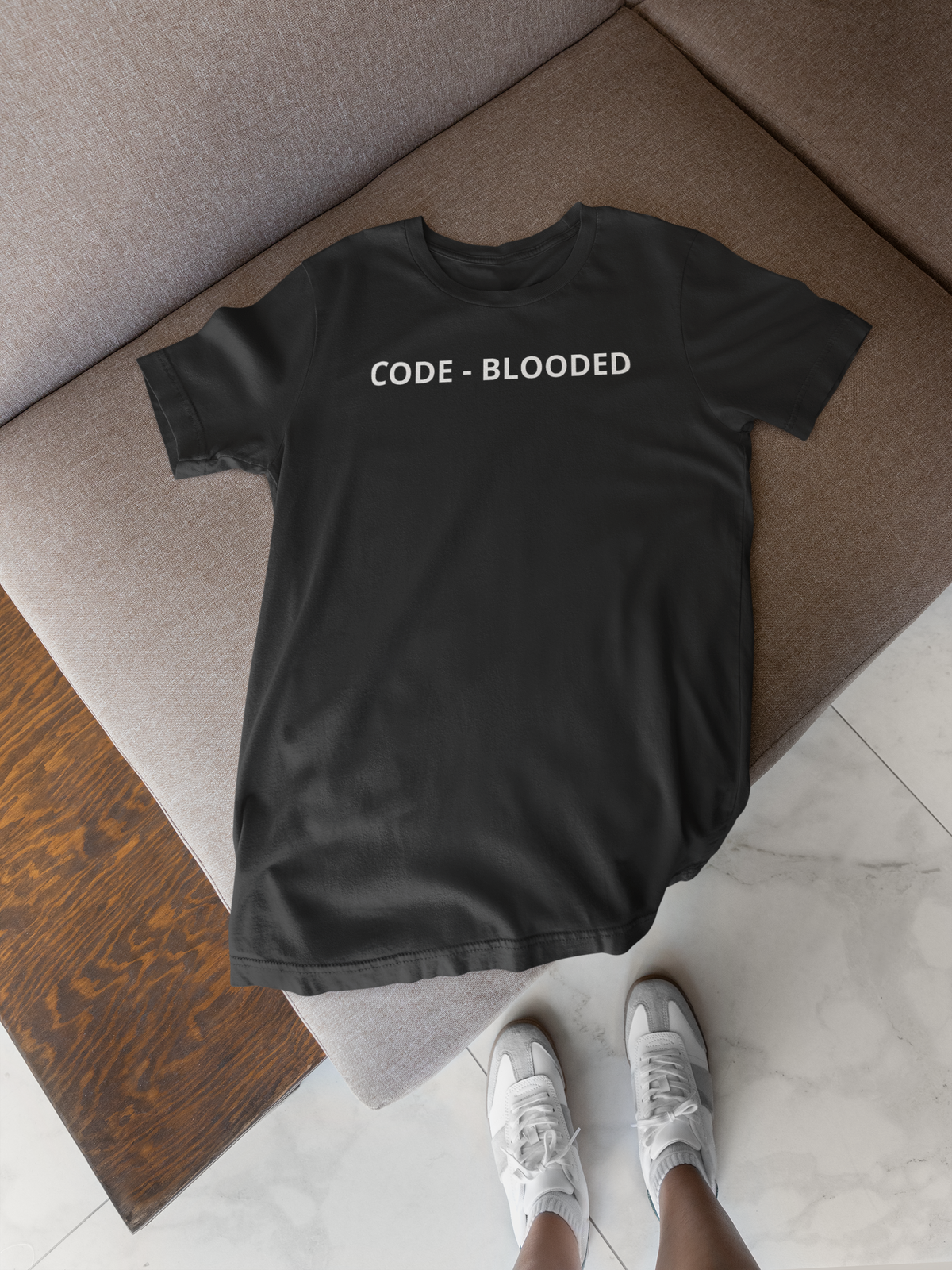 'Code - Blooded' oversized t-shirt in black, flat lay on rug with sneakers, funny gift for programmers
