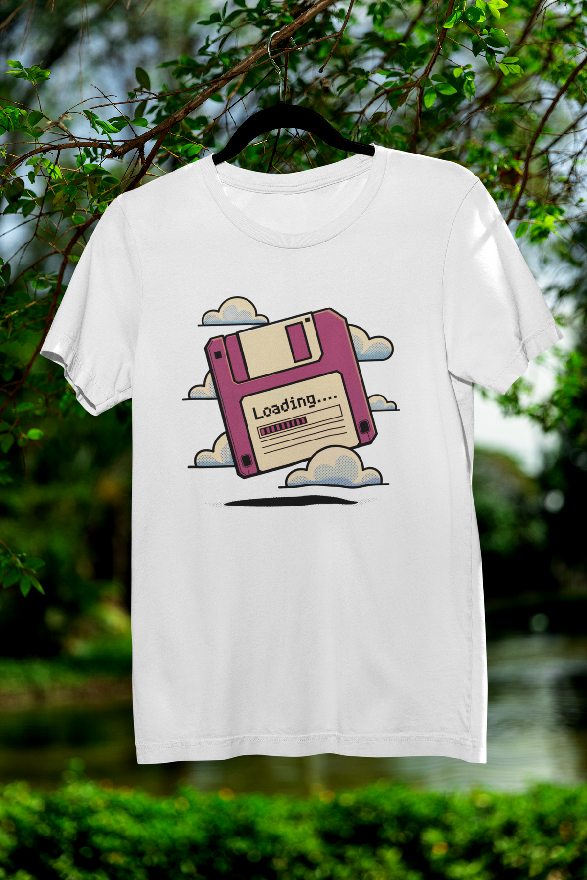 'Floppy Disk Loading' t-shirt in white, hanging outdoors among trees, funny retro tech gift idea