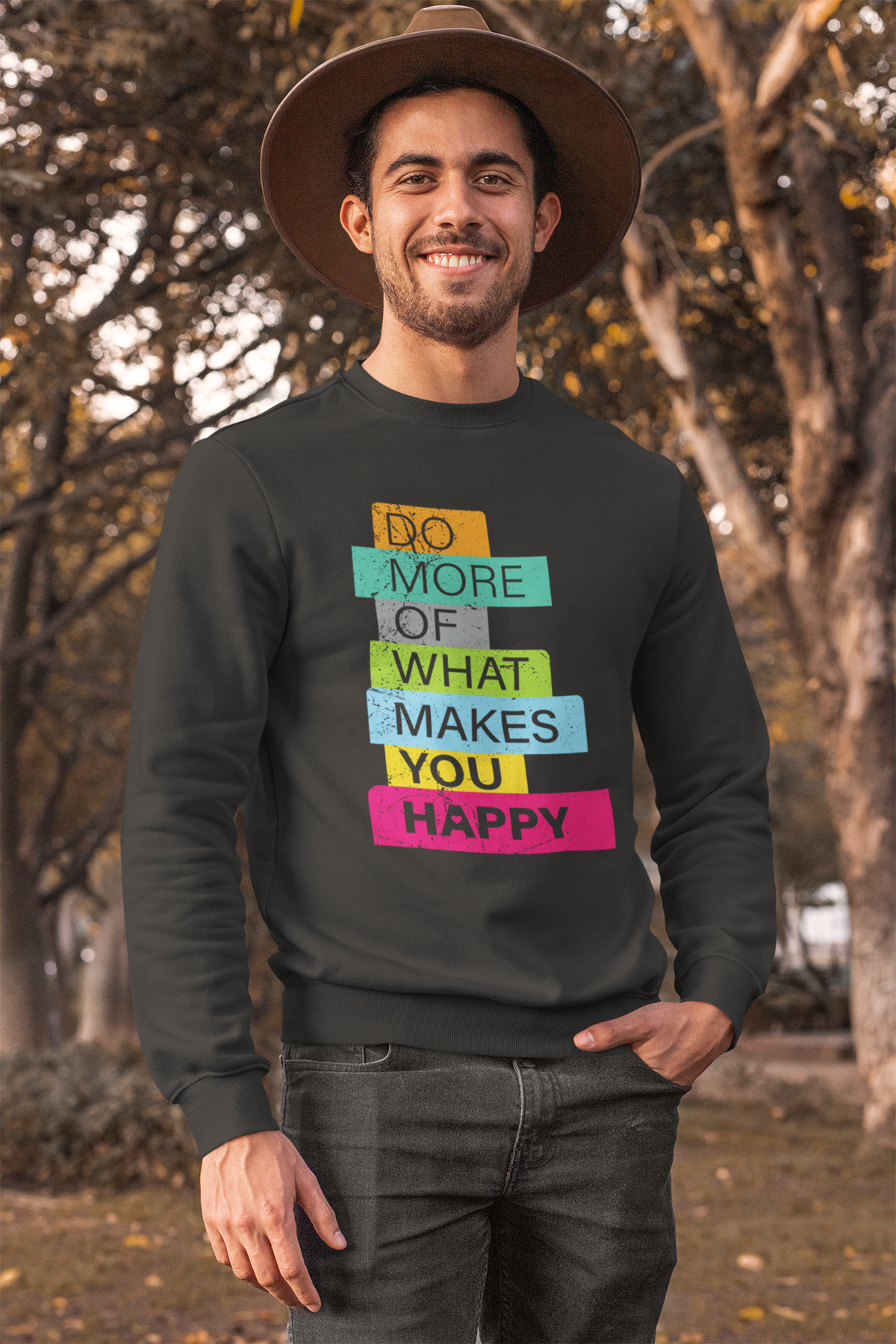 'Do More of What Makes You Happy' sweatshirt in black, man in a hat wearing it outdoors, uplifting gift