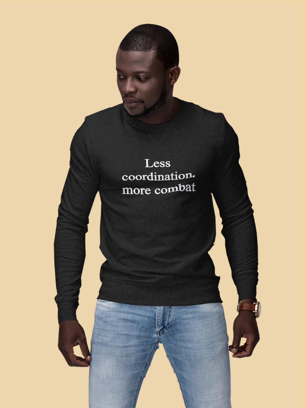 'Less Coordination More Combat' sweatshirt in black, man modeling it on tan background, funny sarcastic gift