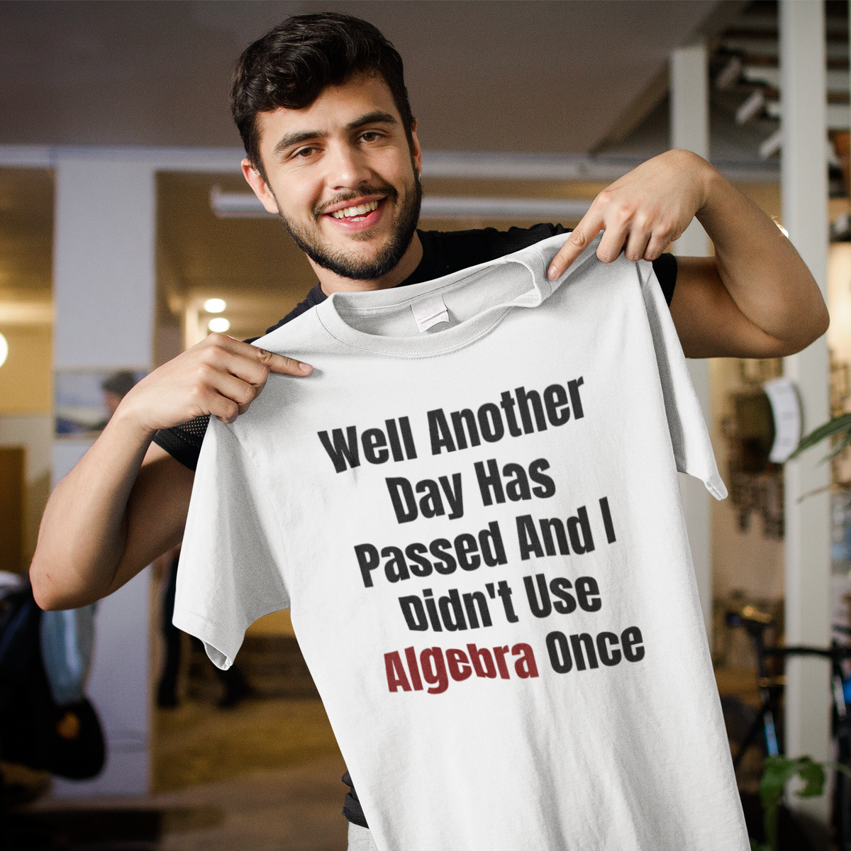 "Well Another Day Has Passed And I Didn't Use Algebra Once" t-shirt in white, man holding it up