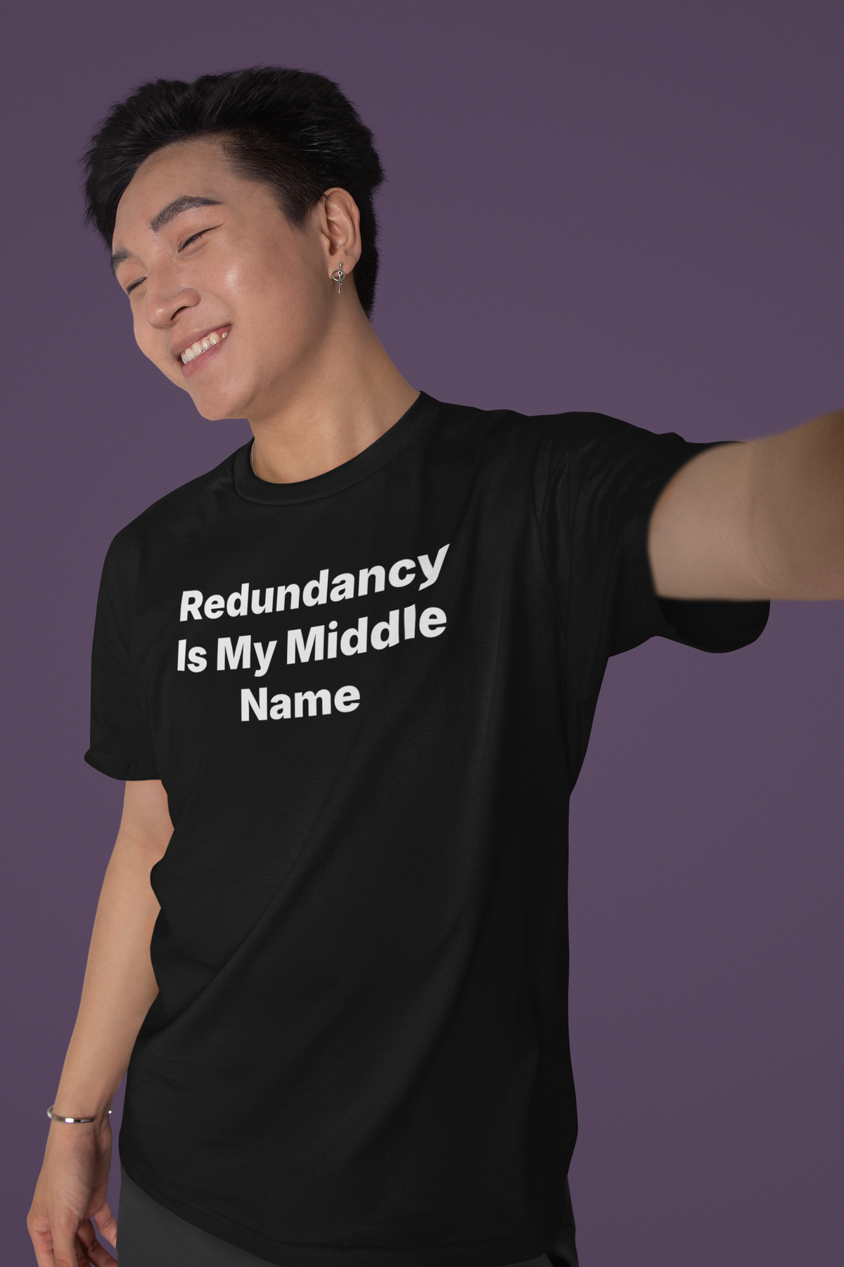 'Redundancy Is My Middle Name' t-shirt in black, man wearing it on purple background, funny IT tee gift