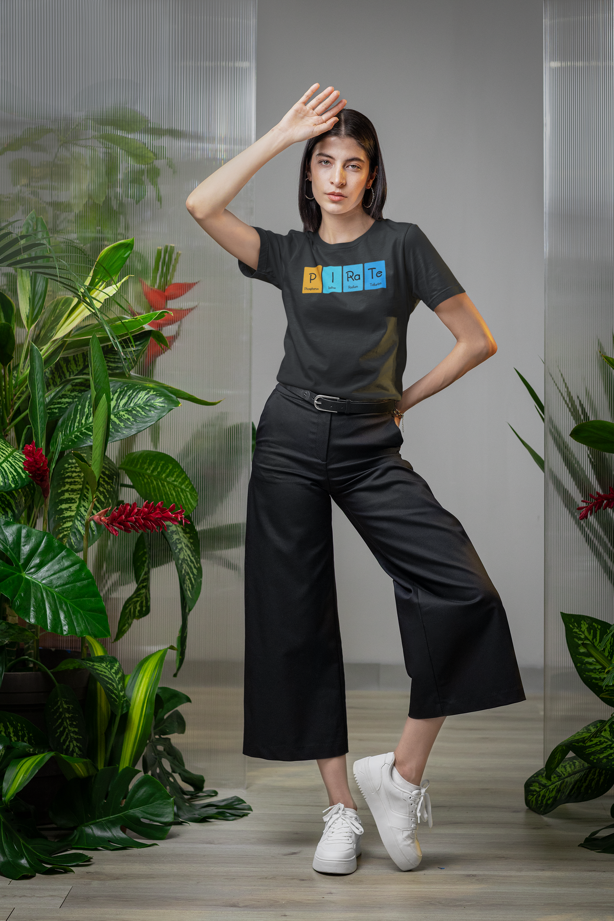 'P-I-Ra-Te' periodic table t-shirt in black, woman posing among plants, funny science pun tee