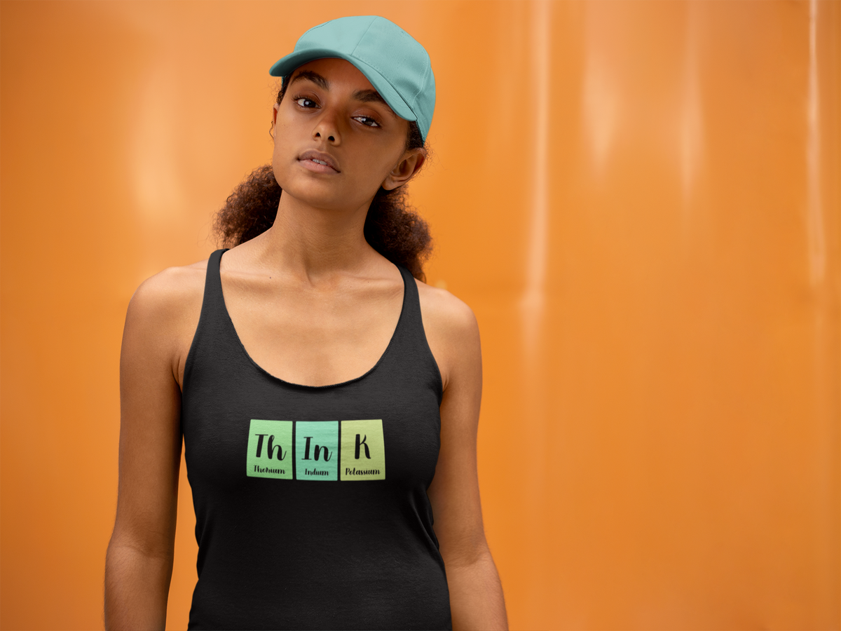 'Th-In-K Periodic Table Women's Tank' in black, woman by an orange wall, Tank Top mockup, Geekpsters