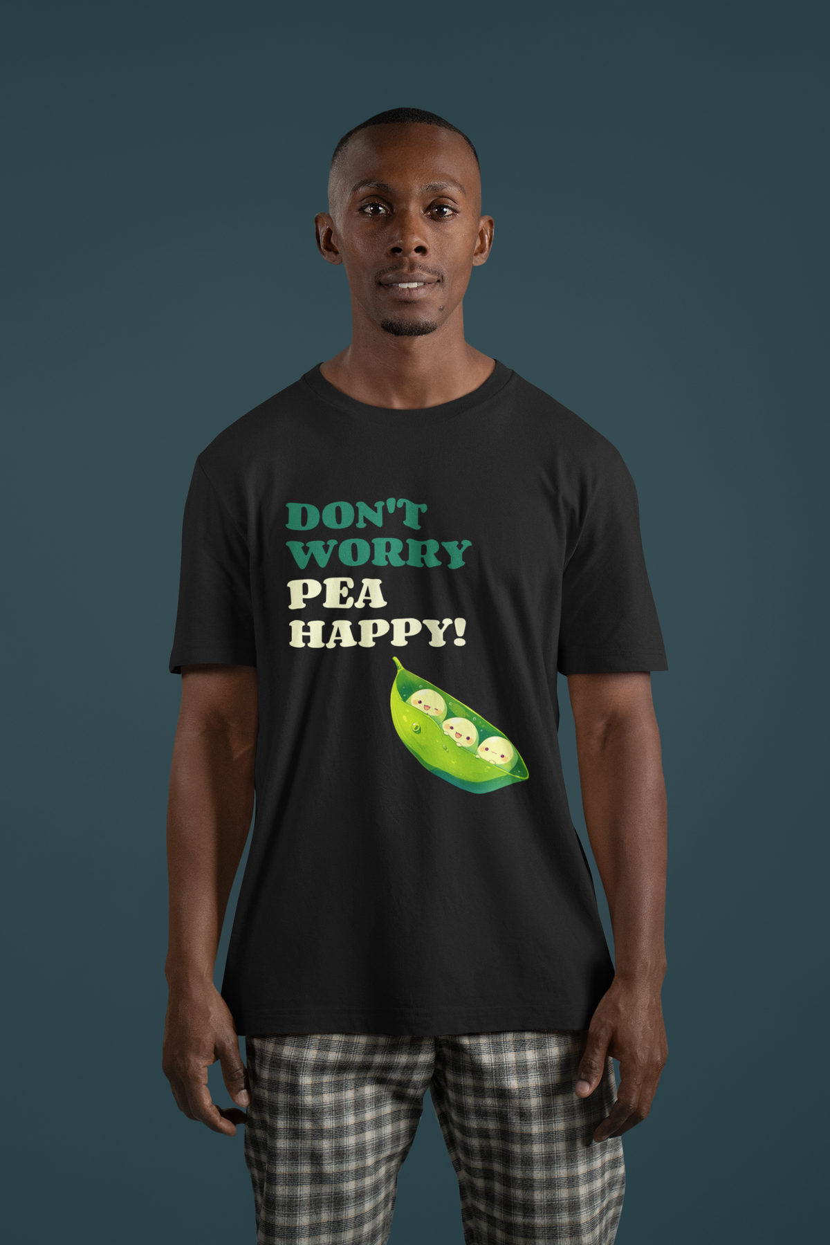 'Don't Worry Pea Happy' pea pod pun t-shirt in black, man wearing it on teal background, funny foodie gift