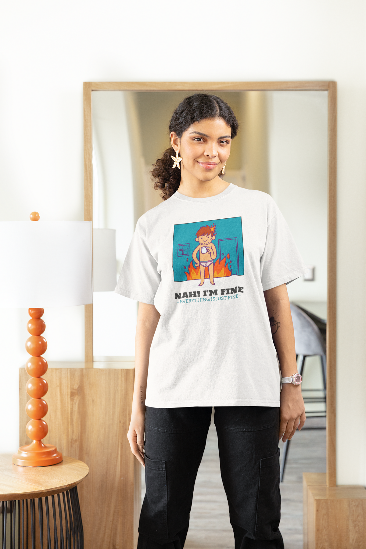'Nah! I'm Fine' this is fine meme t-shirt in white, woman wearing it indoors, funny sarcastic gift idea