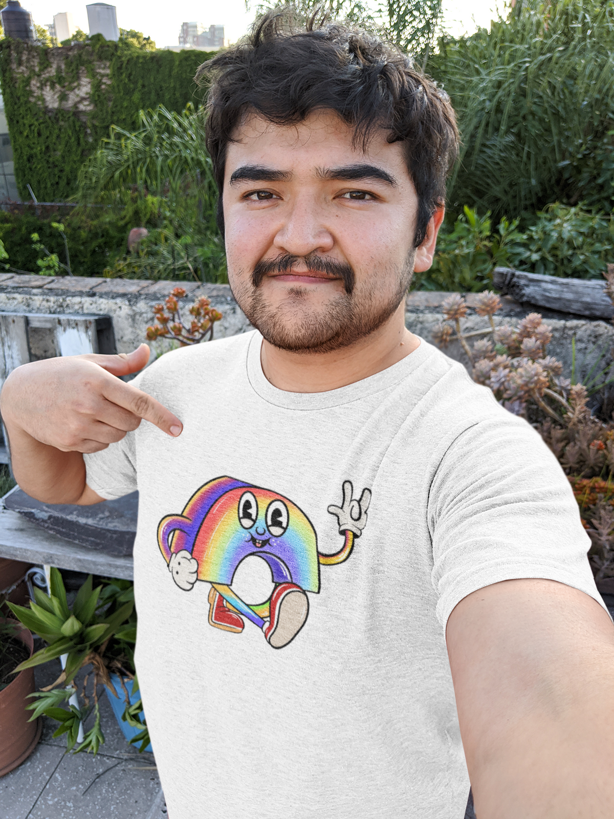 Cartoon rainbow character t-shirt in white, man pointing at the print, funny quirky gift idea