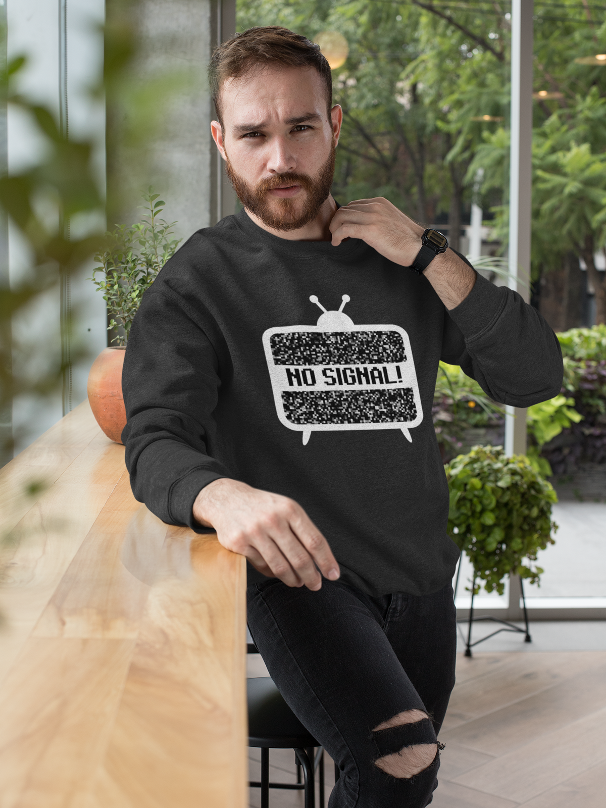 'No Signal' crewneck sweatshirt in charcoal grey, man wearing it outdoors on patio, funny retro TV gift