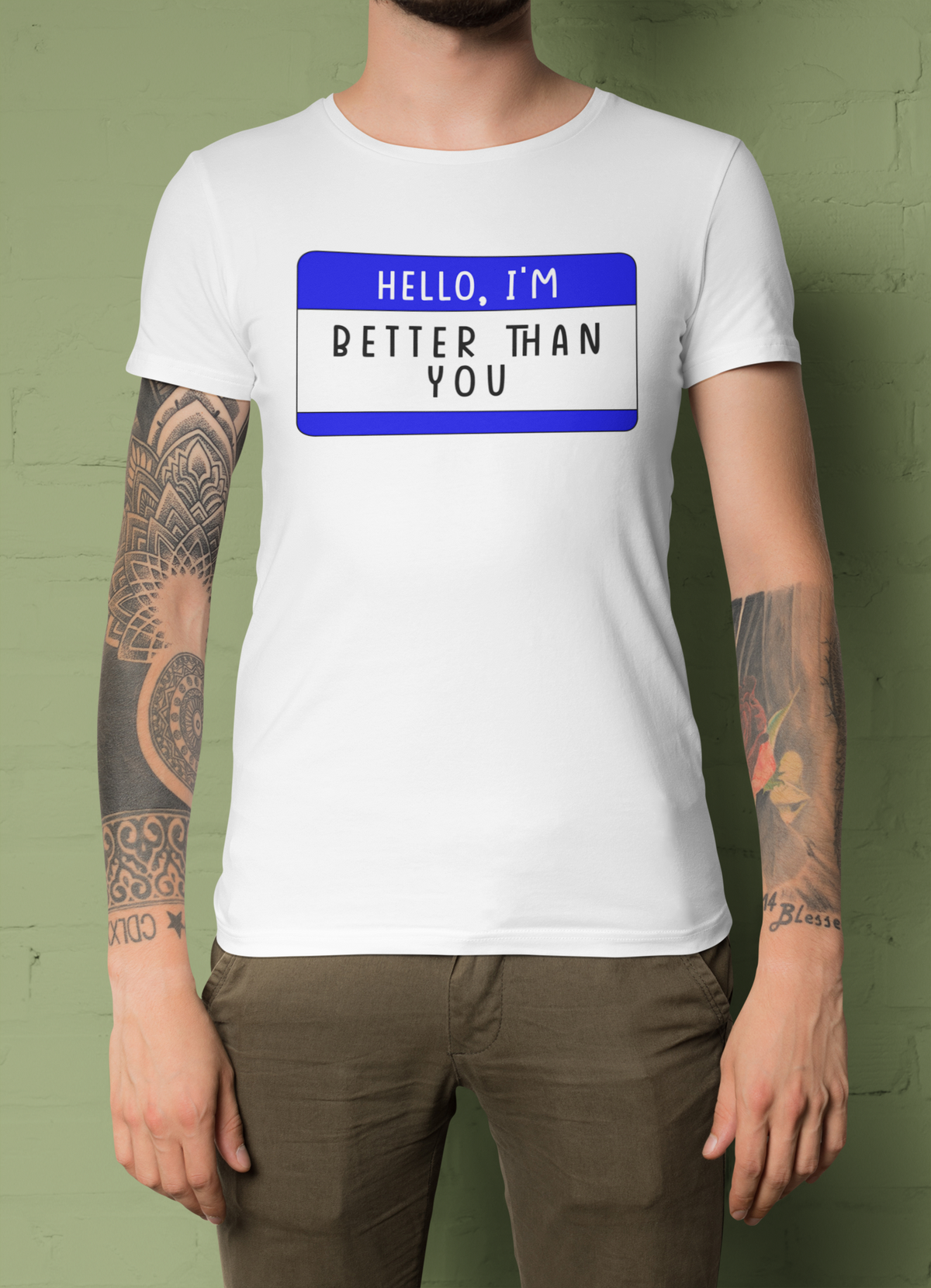Hello I'm Better Than You name tag T-shirt in white, tattooed woman wearing it, green backdrop, gift tee