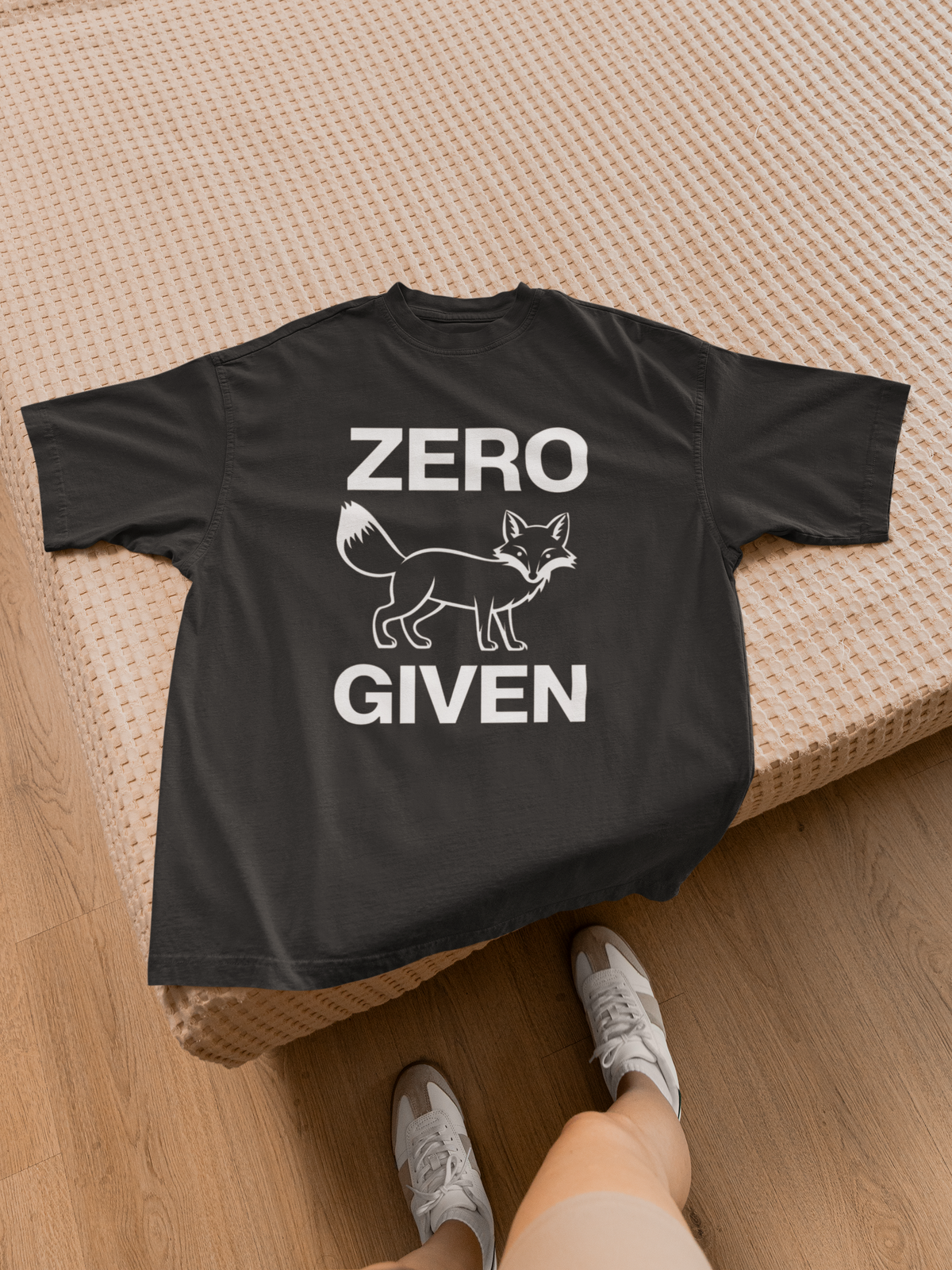 "Zero Fox Given" women's tee in black, folded flat lay by a bed, funny sarcastic gift shirt
