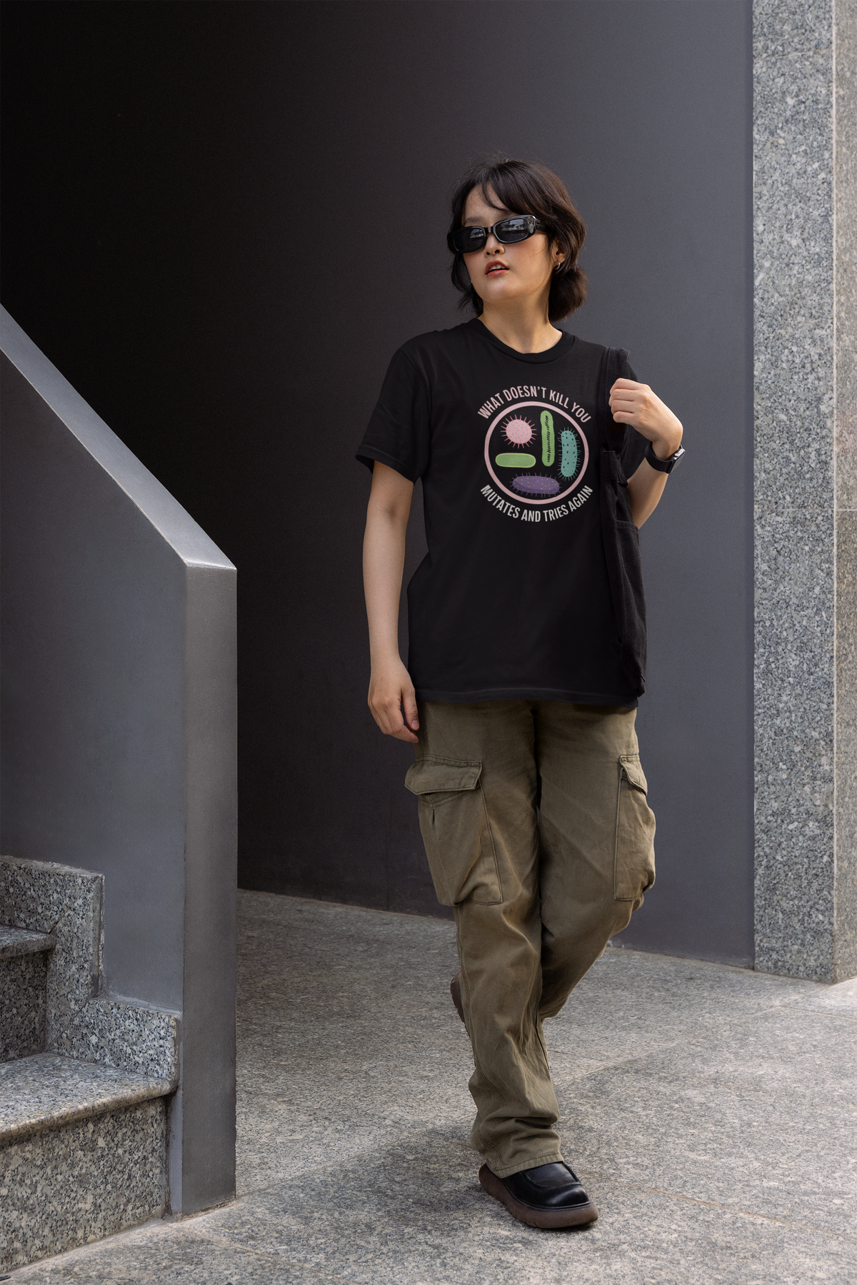 'What Doesn't Kill You' women's tee in black, woman wearing it outdoors, funny science pun gift