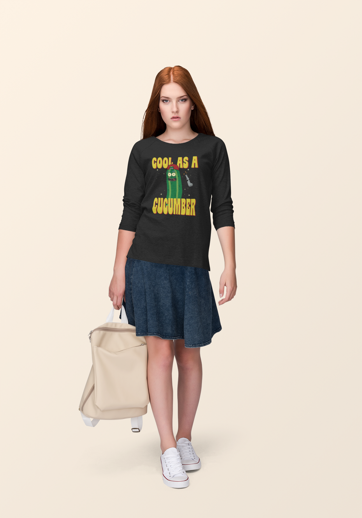 "Cool As A Cucumber" cartoon graphic tee in black, redhead woman wearing it with a suitcase, funny pun style
