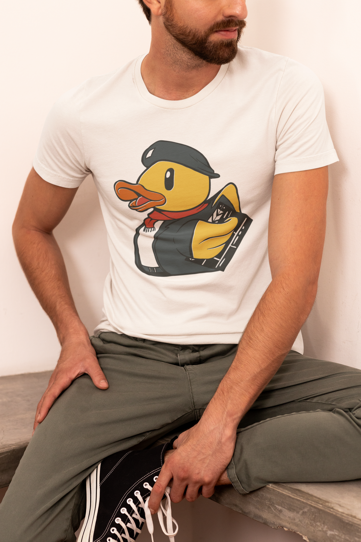 Director duck t-shirt in white, man model seated wearing it, funny gift for filmmakers