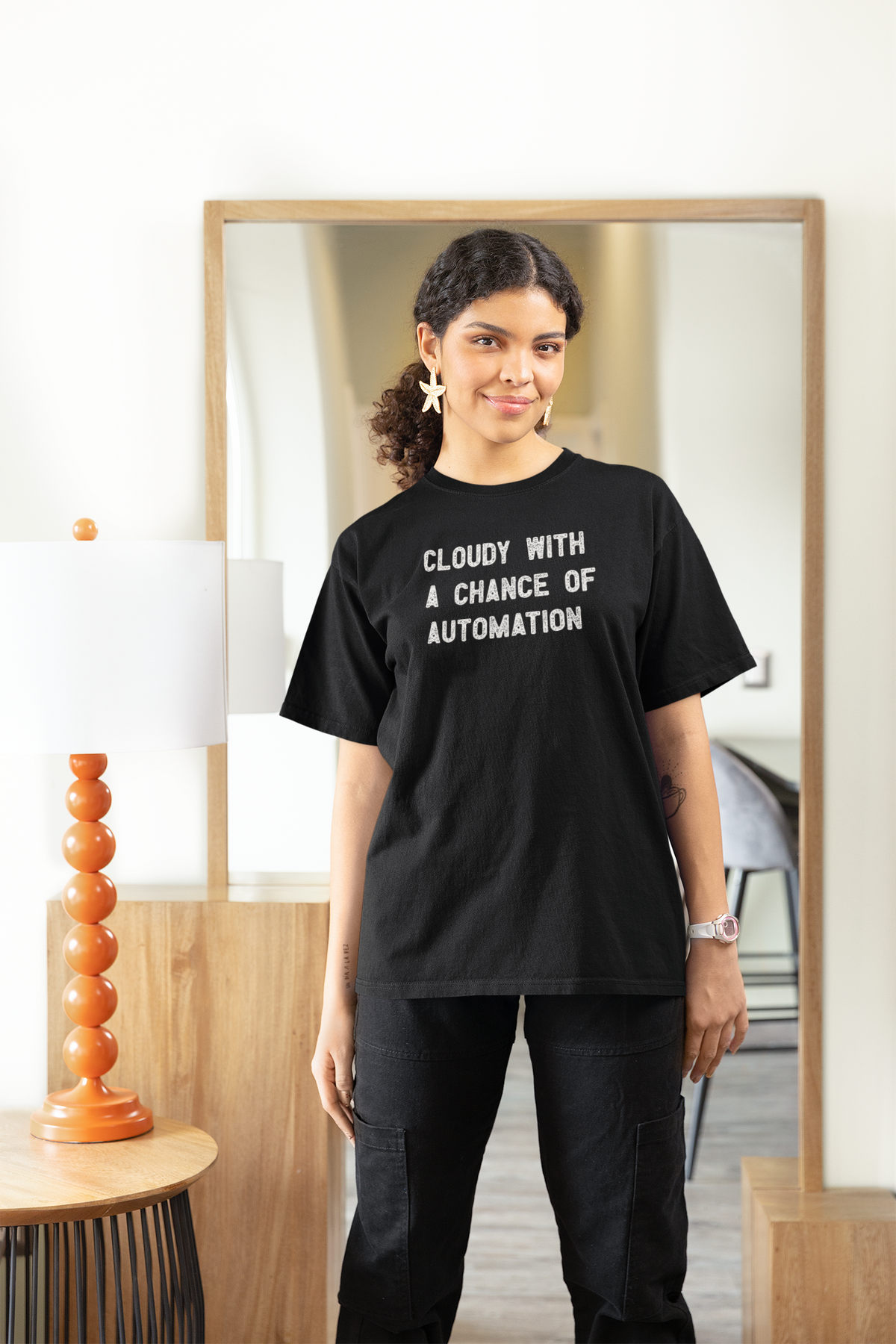 'Cloudy With a Chance of Automation' t-shirt in black, woman wearing it at home, funny gift for female engineers
