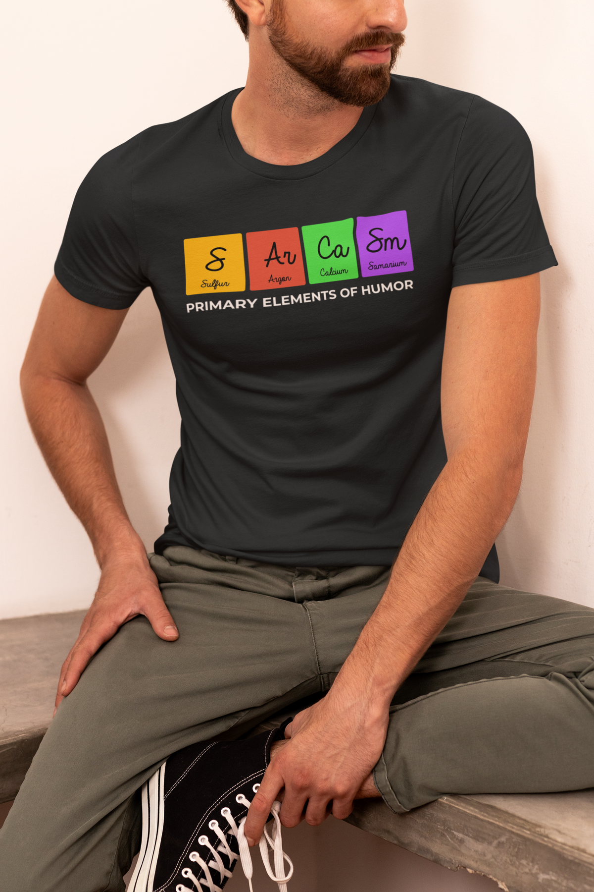 'Sarcasm, Primary Elements of Humor' periodic table t-shirt in black, bearded man sitting outdoors, funny gift