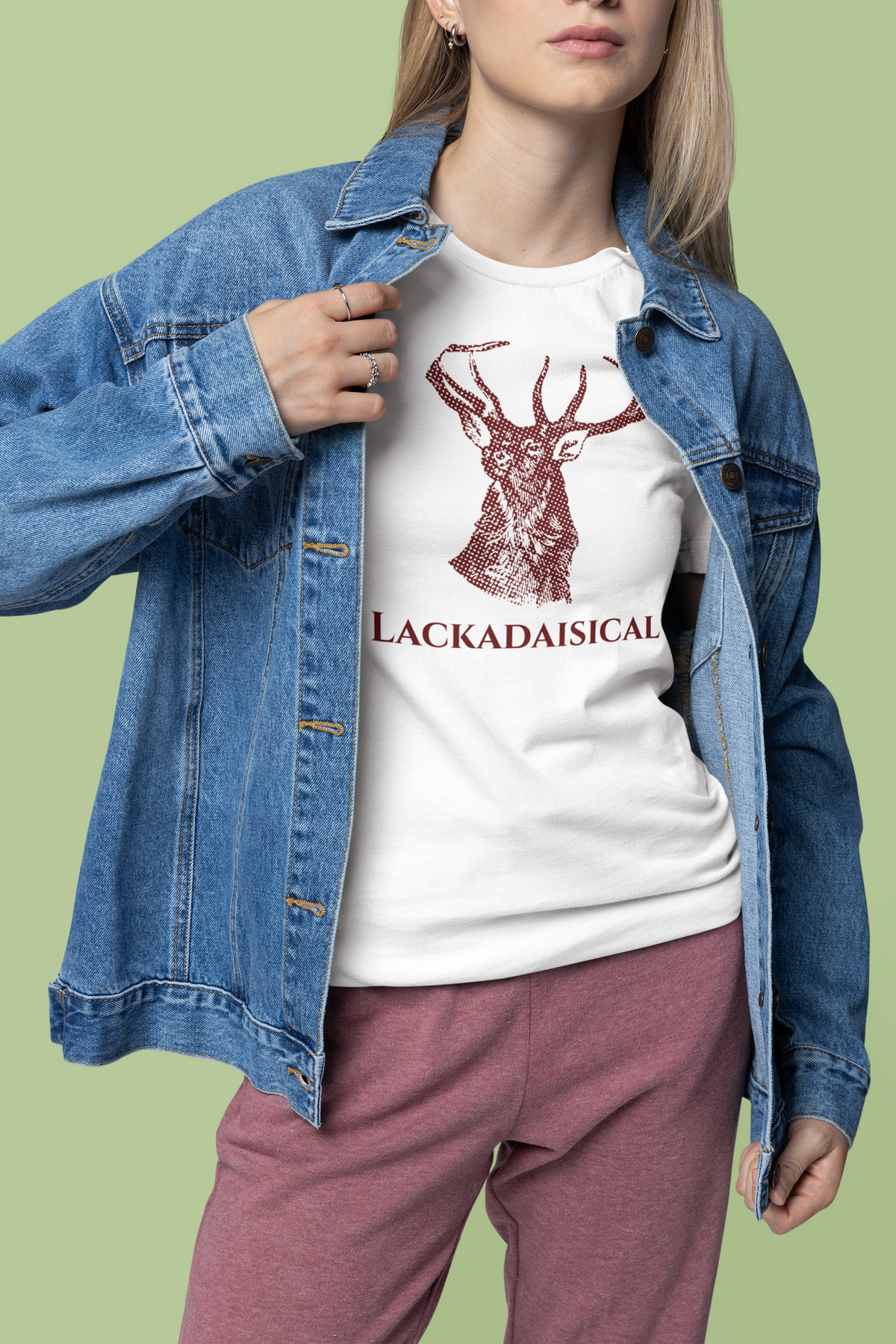 'Lackadaisical' stag deer t-shirt in white, woman in denim jacket wearing it, funny nature pun gift