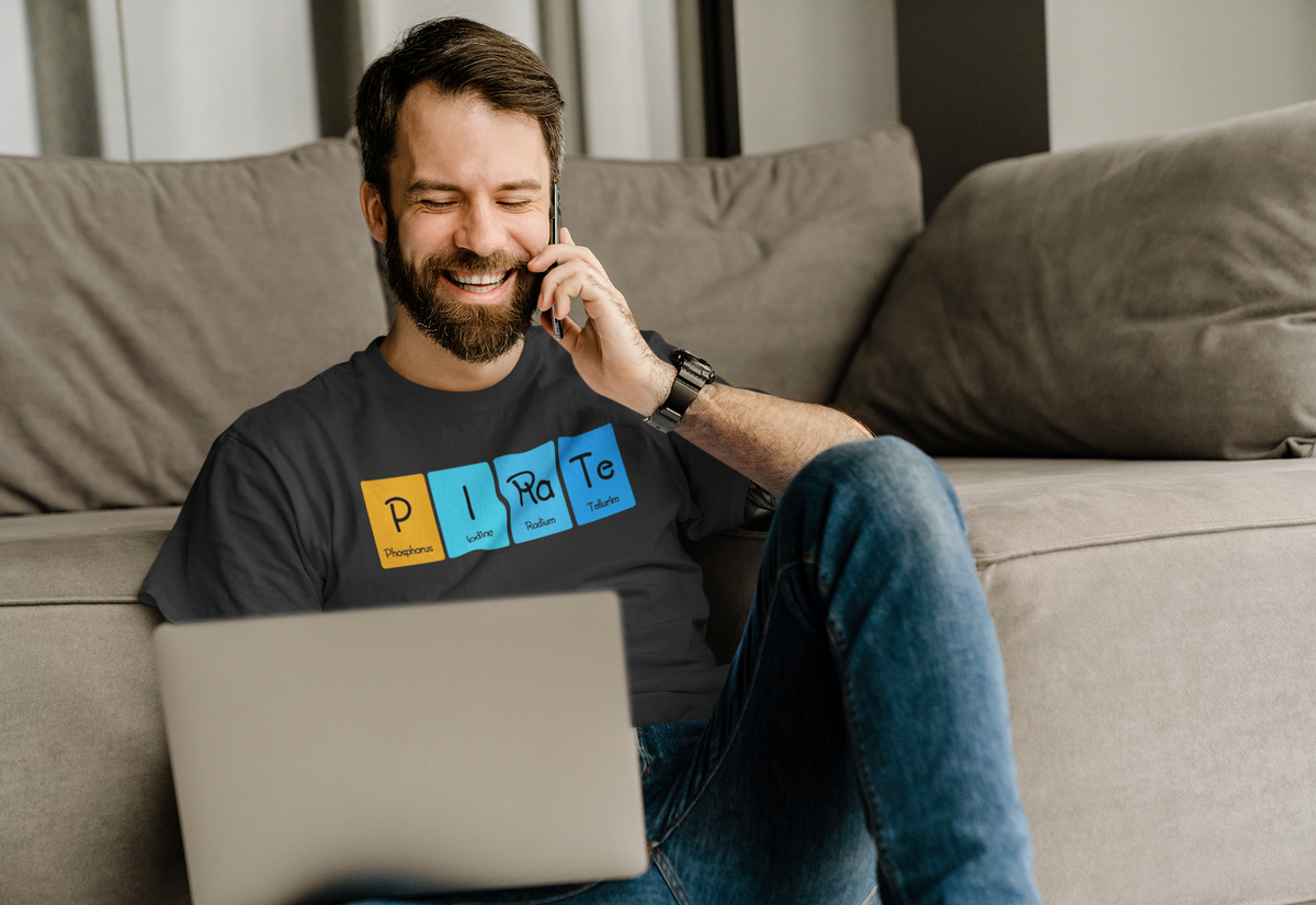 'P-I-Ra-Te' periodic table t-shirt in black, man on the phone at home wearing it, casual lifestyle photo