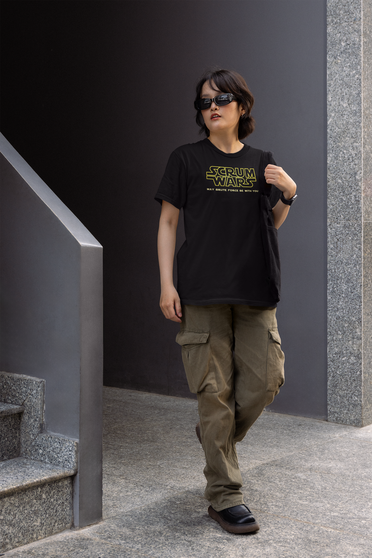 "Scrum Wars" women's tee in black, woman walking outdoors near stairs, funny gift for agile developers