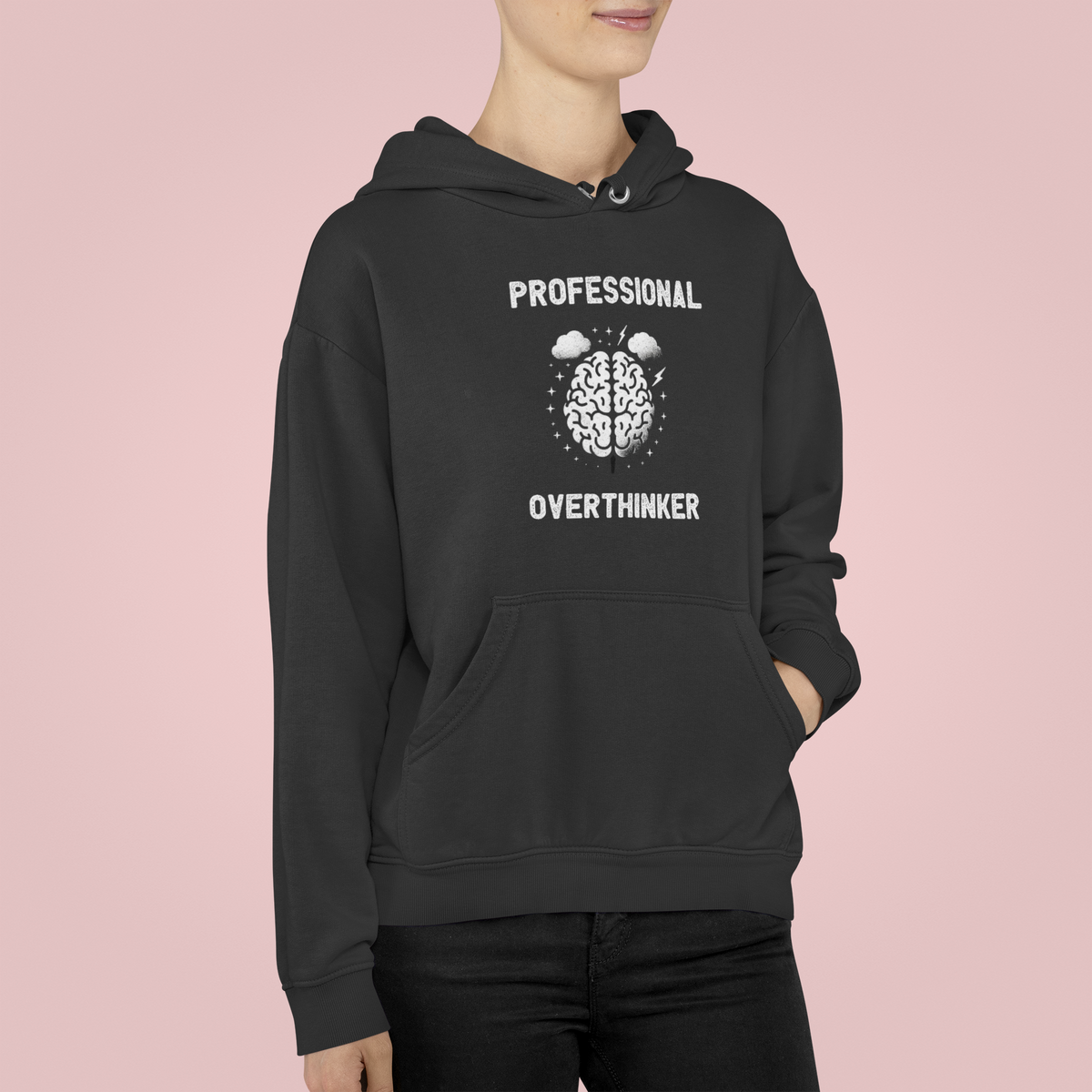 "Professional Overthinker" hoodie in black, woman wearing it on a pink background, funny gift