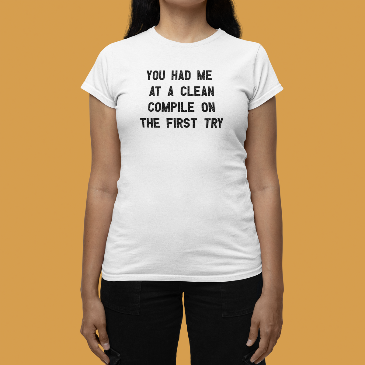 'You Had Me at a Clean Compile on the First Try' women's tee in white, woman wearing it in a studio, funny programmer gift
