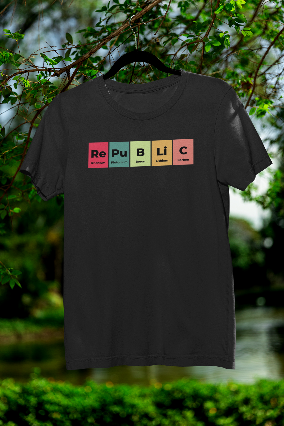 'Republic' periodic table t-shirt in black, hanging on a tree branch outdoors, funny science pun tee