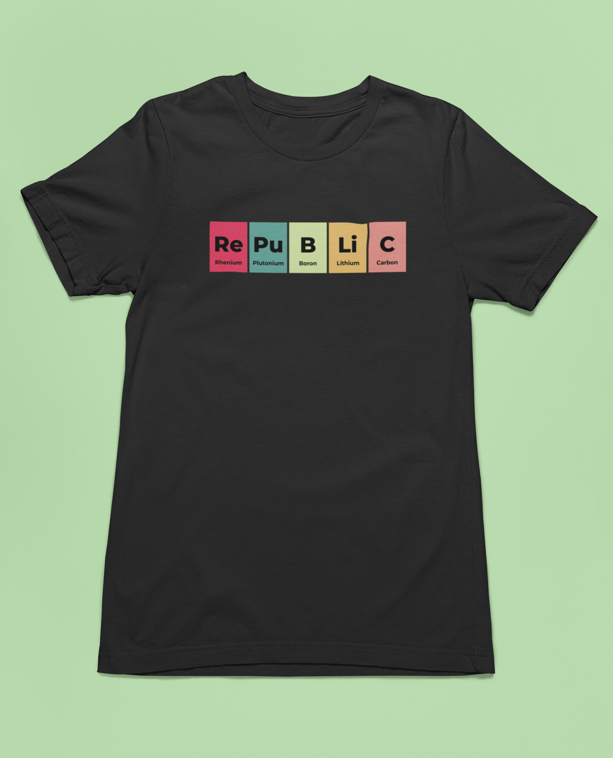'Republic' periodic table t-shirt in black, flat lay front on green background, funny chemistry pun gift