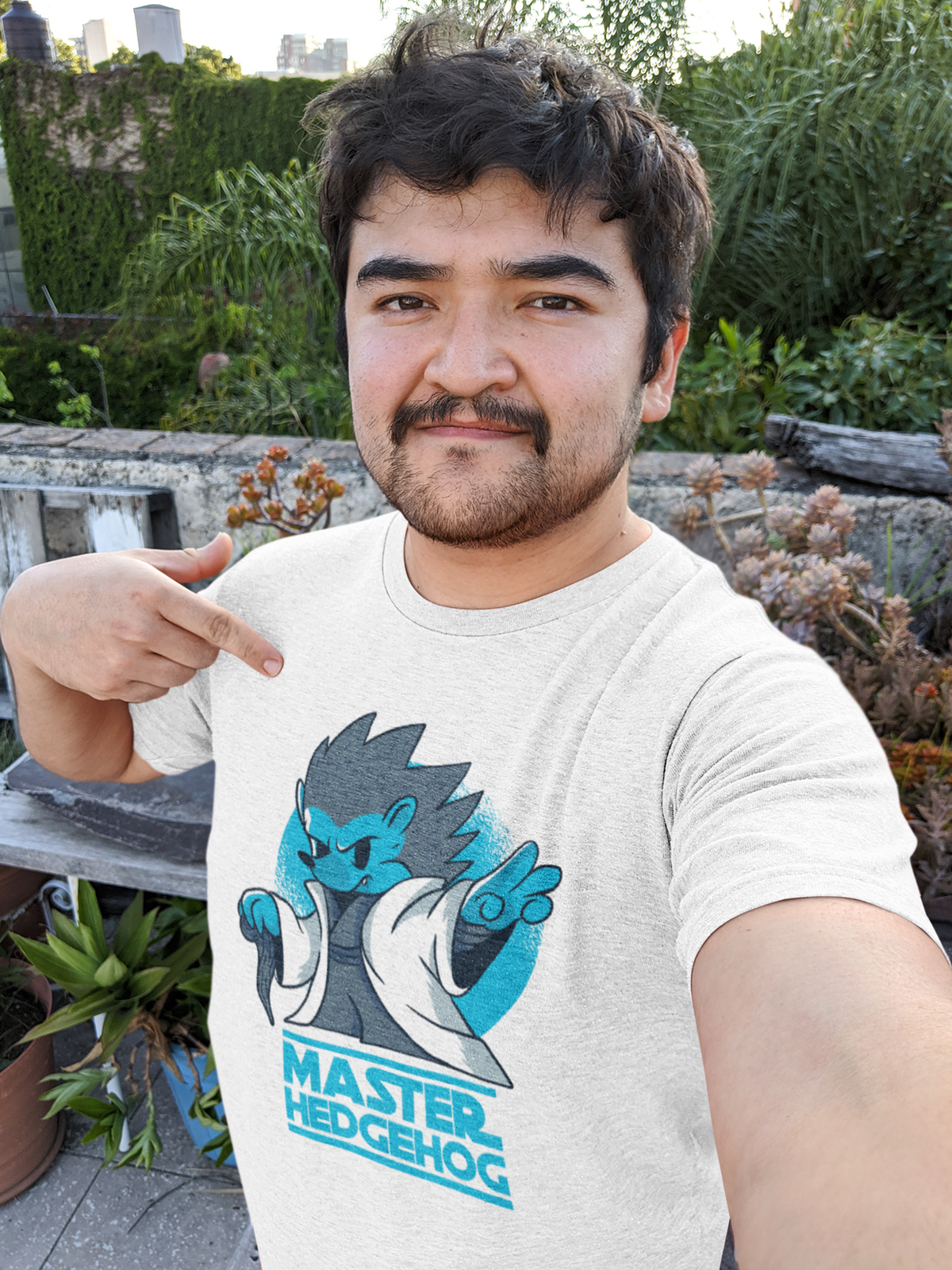 'Master Hedgehog' t-shirt in white, smiling man pointing at it outdoors