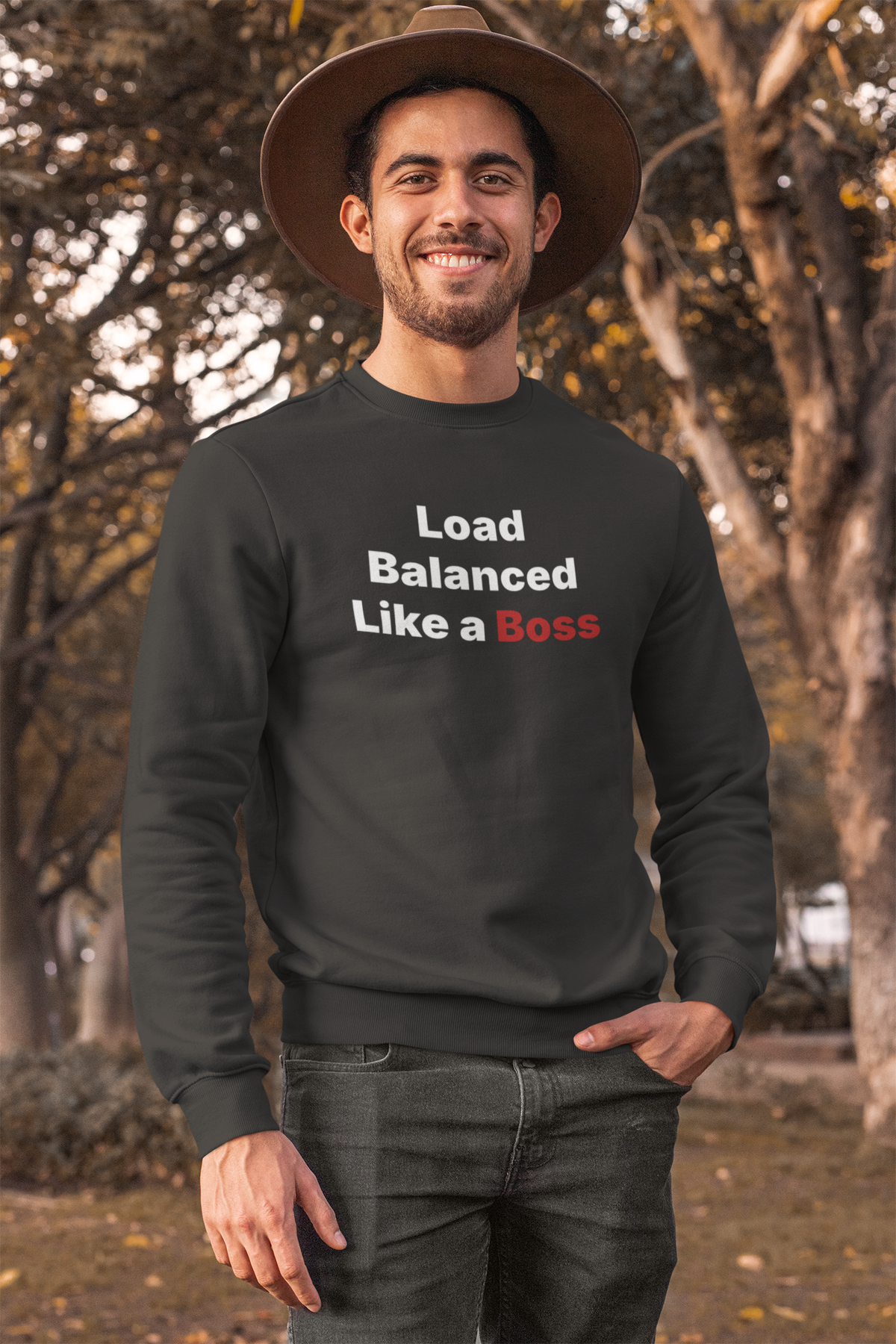 'Load Balanced Like a Boss' sweatshirt in charcoal, man wearing it outdoors in a hat, funny tech sweatshirt gift
