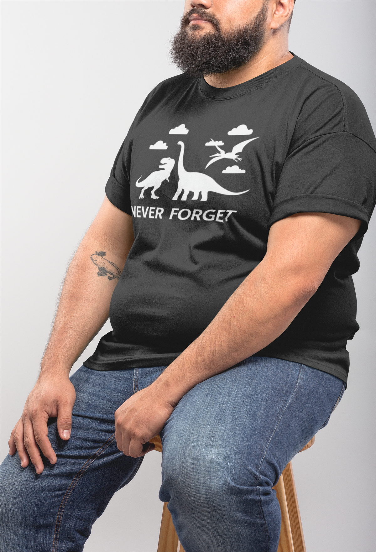 'Never Forget' dinosaur t-shirt in black, bearded man sitting wearing it, funny gift for science lovers