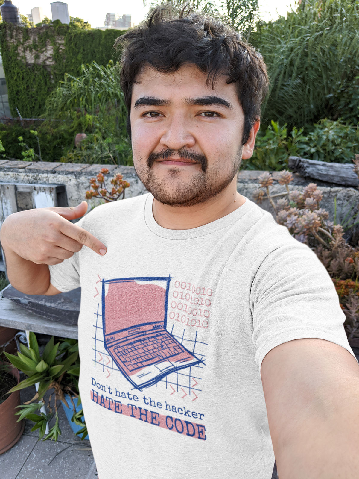 'Don't Hate the Hacker, Hate the Code' laptop t-shirt in white, man model wearing it outdoors, funny developer gift