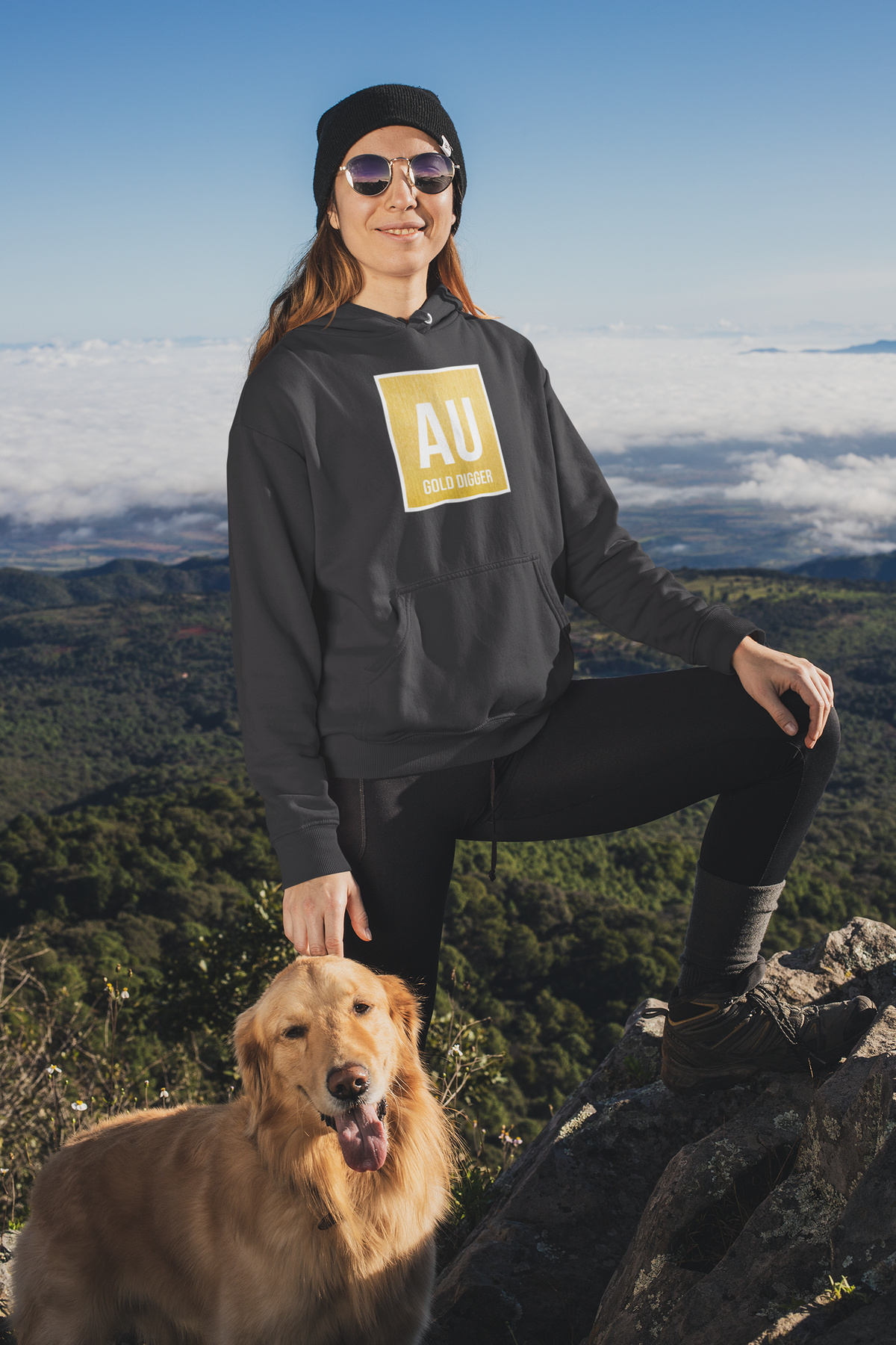 'AU Gold Digger' hoodie in charcoal grey, woman wearing it outdoors on mountain with dog, funny science gift